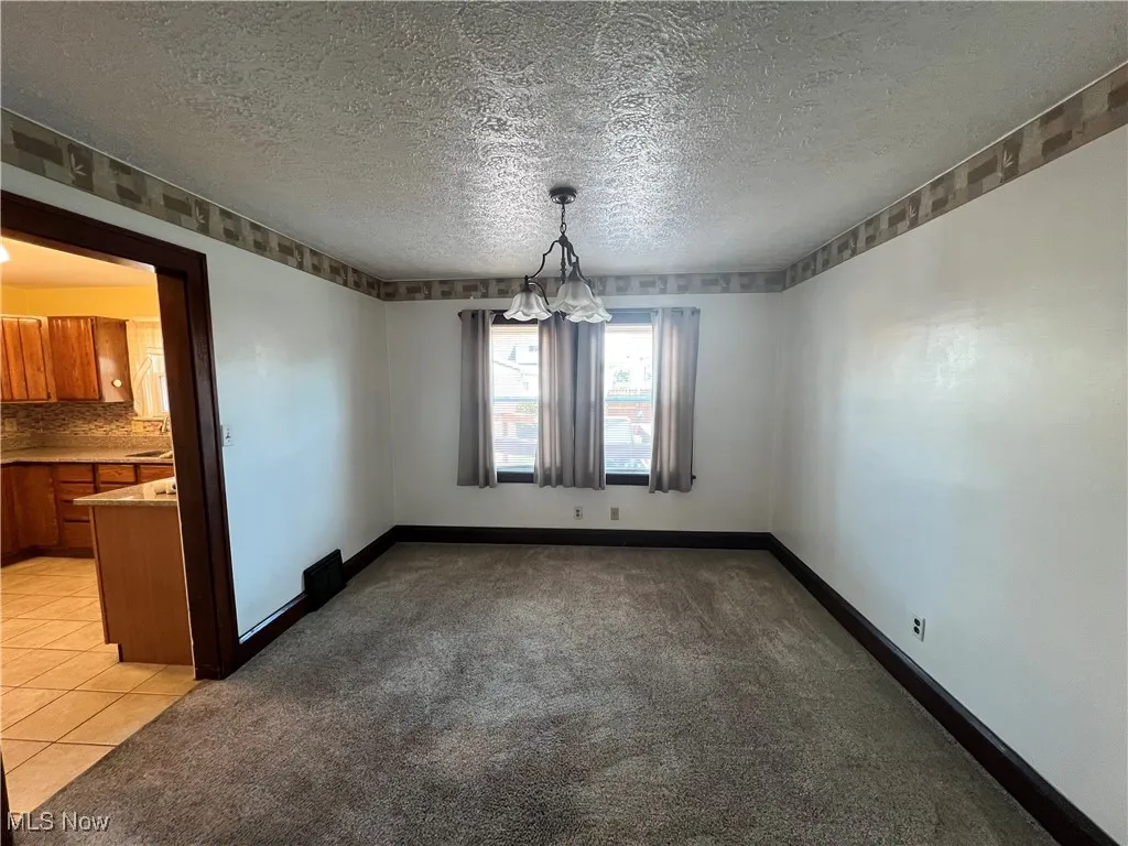 DR with a textured ceiling and light colored carpet