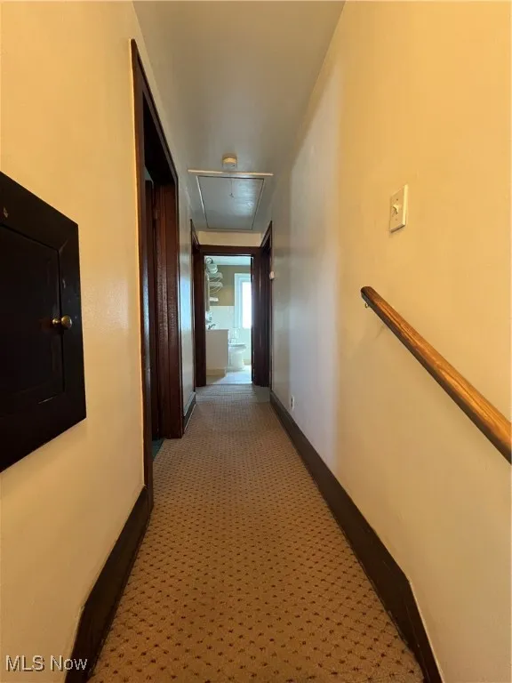 Upstairs hallway featuring carpet flooring and attic access