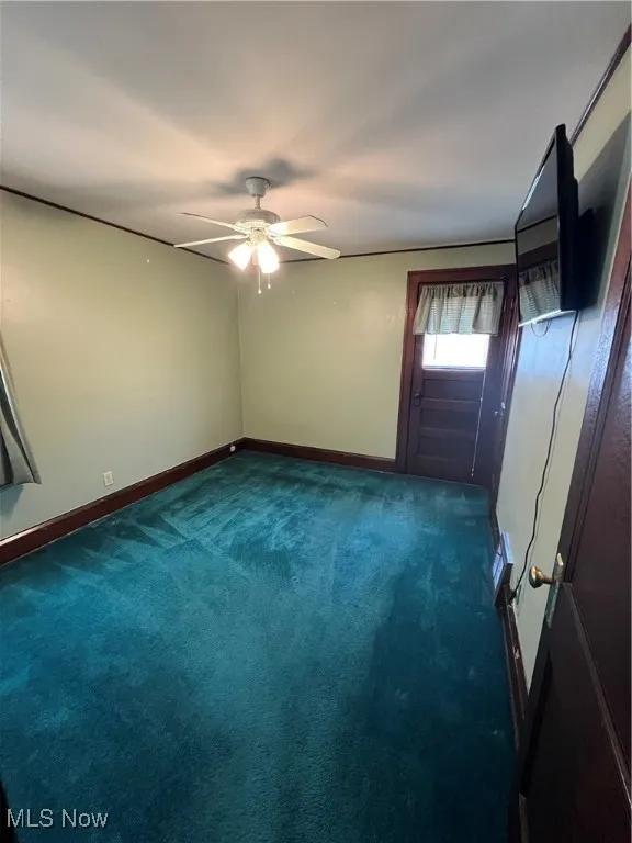 Spare room with ceiling fan and carpet flooring
