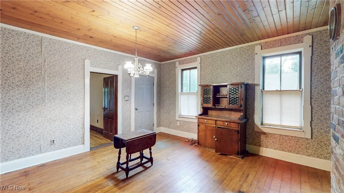 Dining Room area featuring hardwood floor, wood ceiling, place for wood-burning stove, if desired & doorway access to LR & exterior/front porch