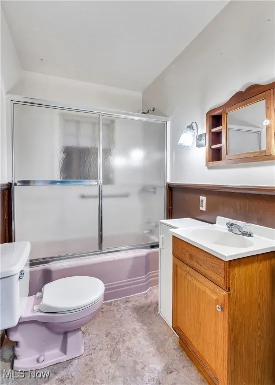 Bathroom with vanity and enclosed tub / shower combo