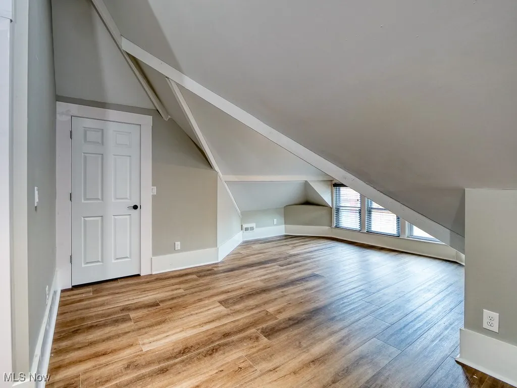 Additional living space featuring vaulted ceiling and light wood-style flooring