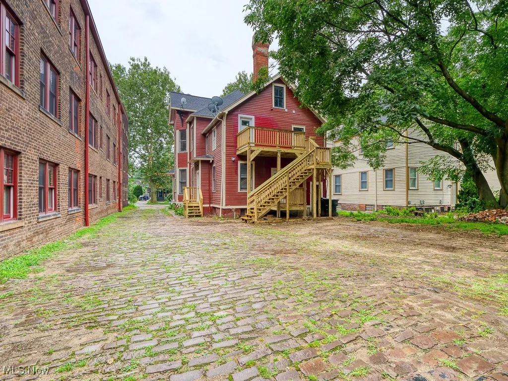 Rear view of house with stairway, a chimney, and a wooden deck