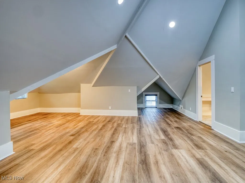 Additional living space with lofted ceiling, light wood-type flooring, and recessed lighting
