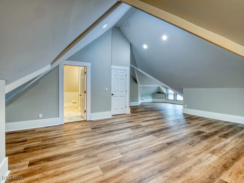 Additional living space featuring vaulted ceiling, light wood-type flooring, and recessed lighting