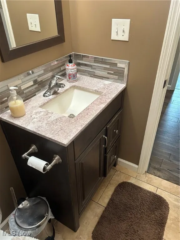 Bathroom featuring vanity, tasteful backsplash, and tile patterned flooring