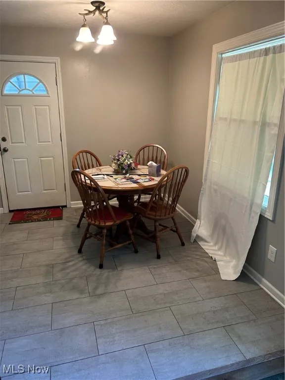 Dining area featuring a chandelier and baseboards