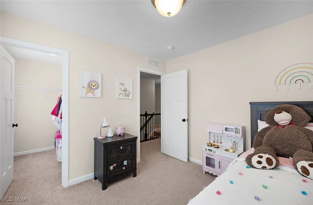 Bedroom featuring light carpet, a closet, and a walk in closet