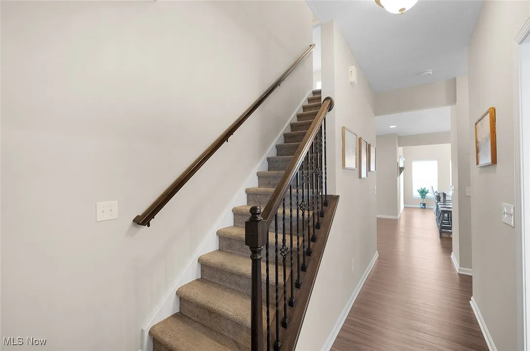 Staircase with wood finished floors and baseboards