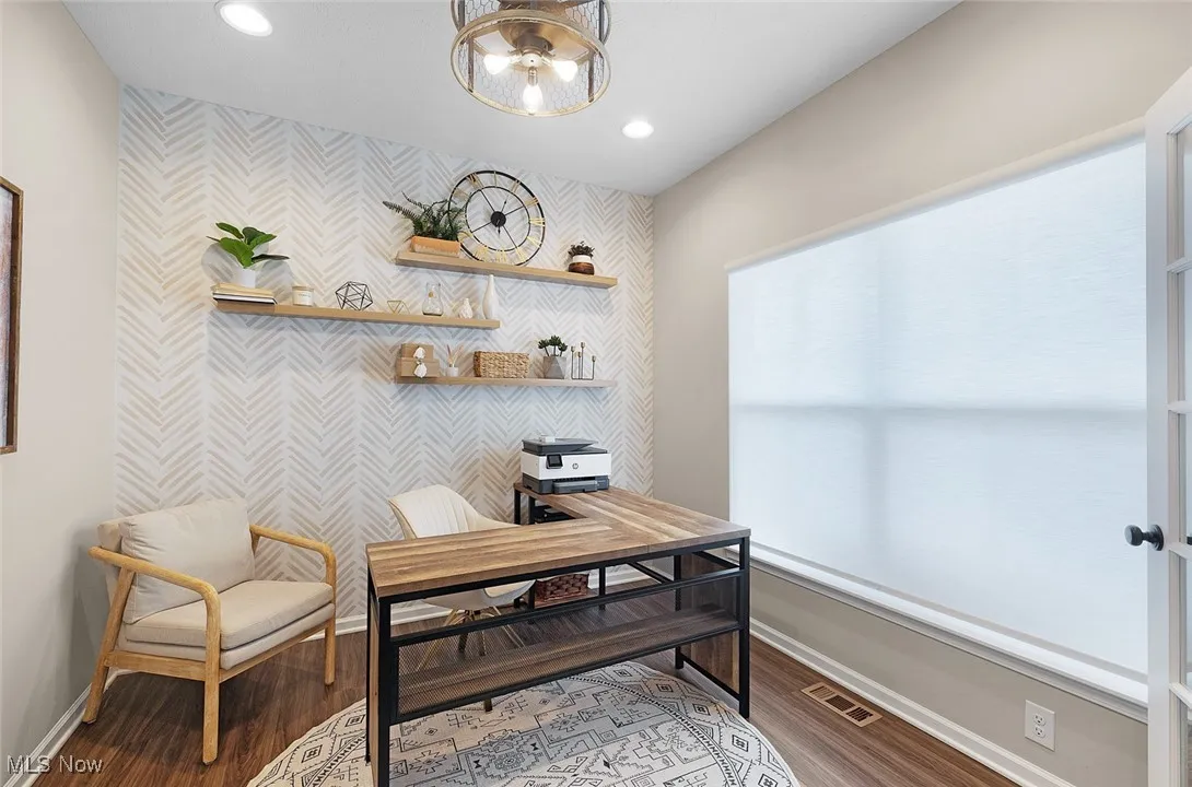 Home office with wallpapered walls, an accent wall, recessed lighting, and wood finished floors