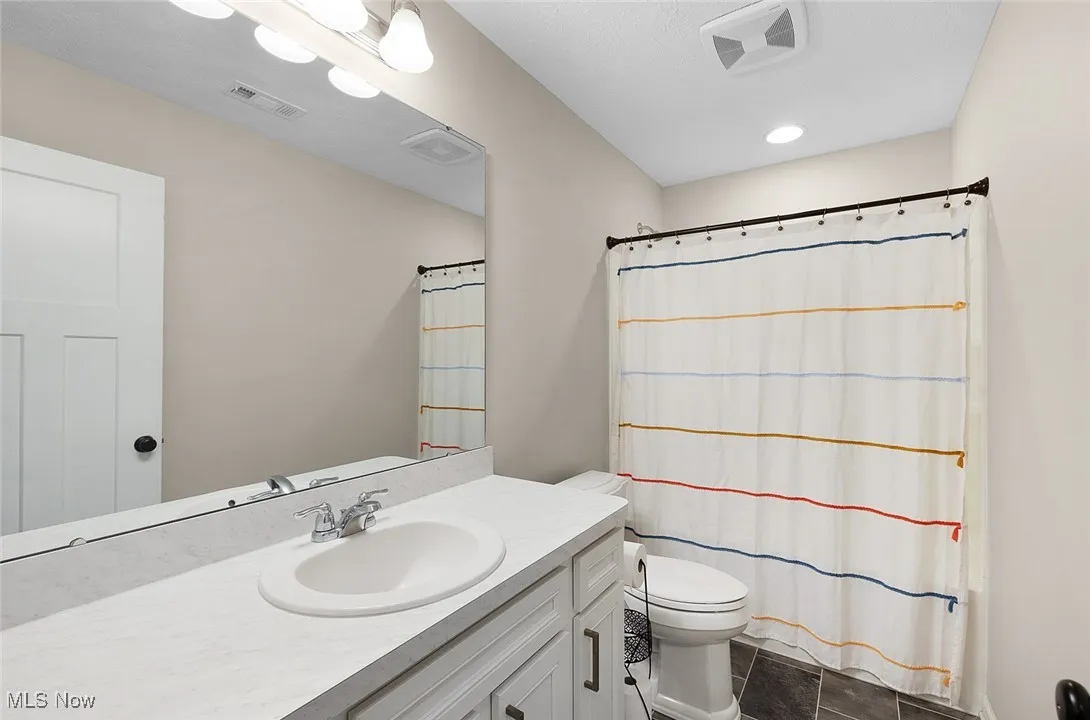 Bathroom featuring vanity and curtained shower