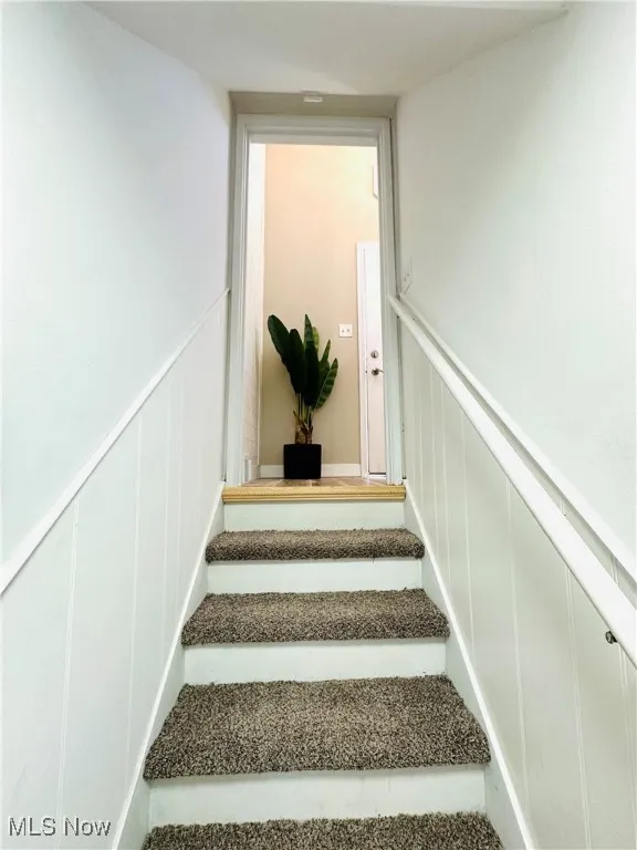 Stairway with a decorative wall and a wainscoted wall
