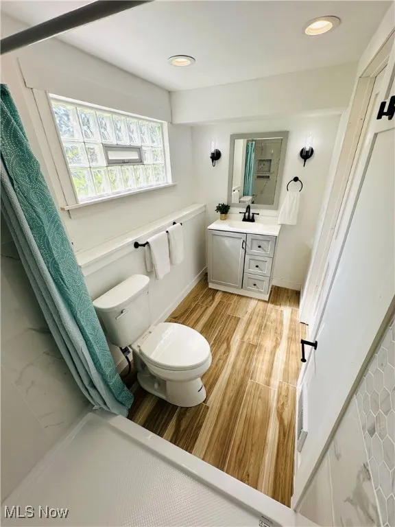 Bathroom featuring vanity, wood like tile floors, and recessed lighting