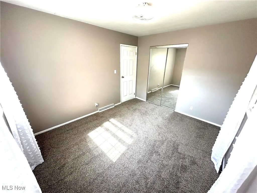 Unfurnished bedroom featuring carpet flooring and a closet