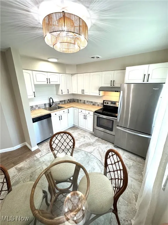 Updated kitchen featuring stainless steel finishes, white cabinets, and new butcher block counters!