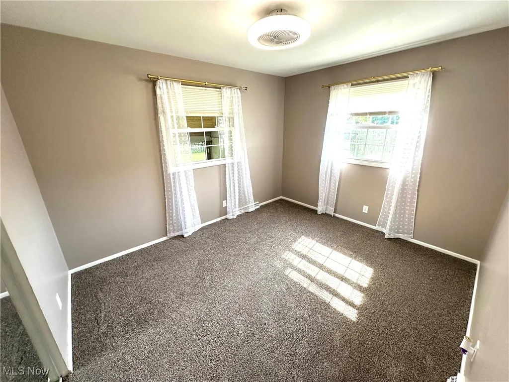 Carpeted empty bedroom featuring baseboards