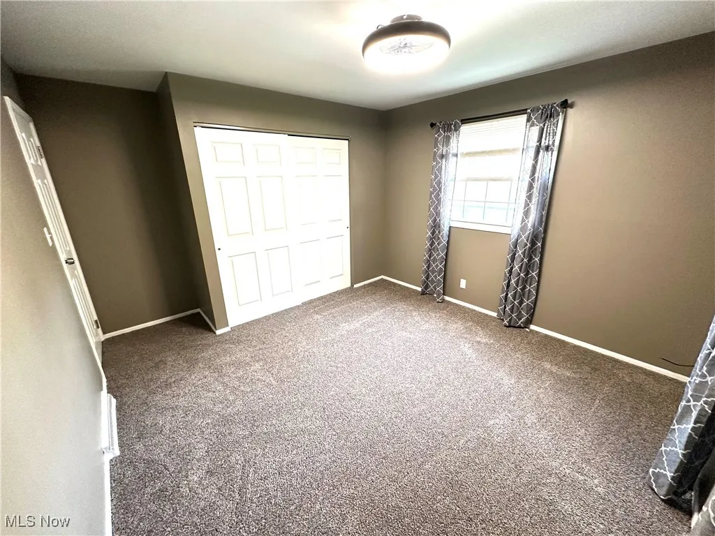 Unfurnished bedroom featuring a closet and carpet floors