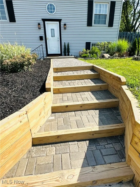 Entrance to property w/ new sidewalk & wood walls!