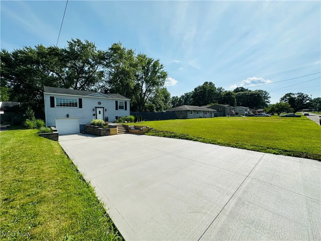 View of front of property with brand new concrete driveway, a front yard, and a garage