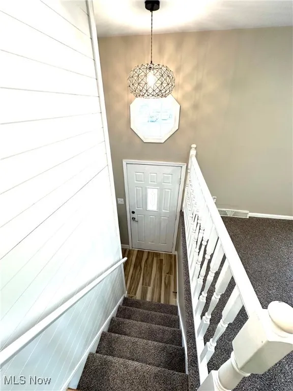 Staircase with baseboards and wood finished tile floors