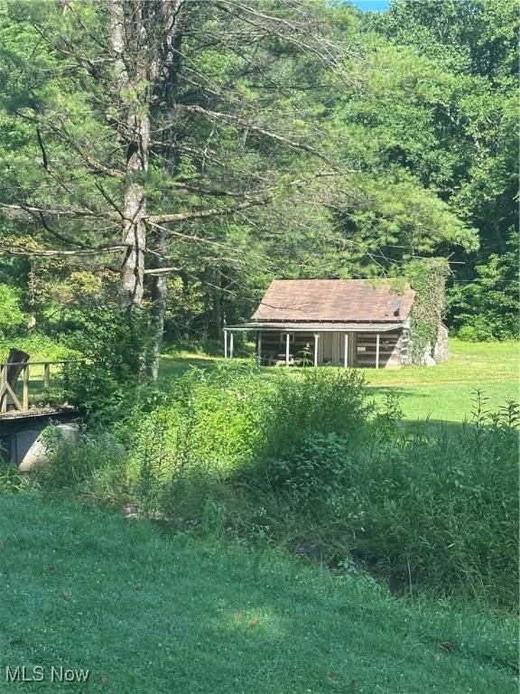 View of grassy yard with a view of trees
