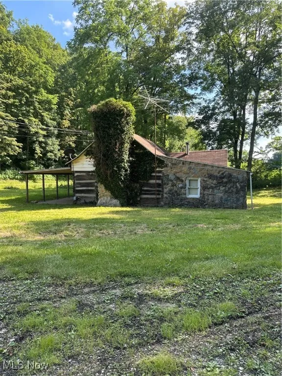 View of grassy yard with a carport