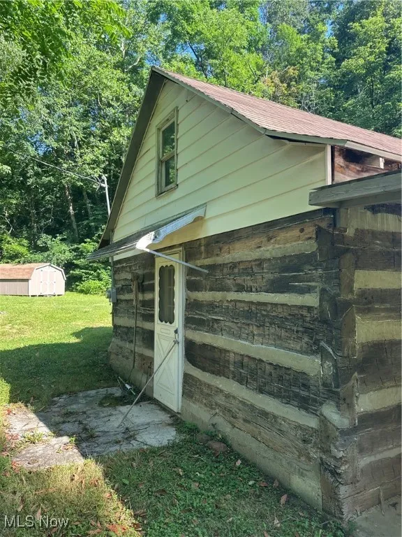 View of home's exterior featuring a yard and a shed