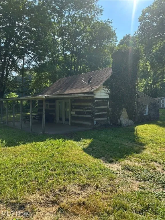 View of grassy yard featuring a patio