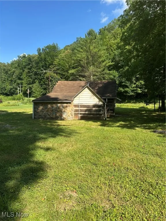 View of grassy yard featuring a wooded view