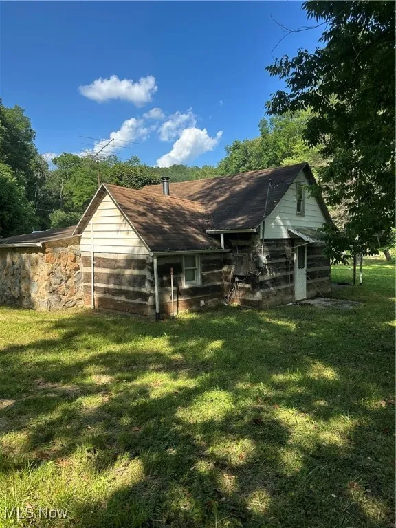 Rear view of property featuring a lawn
