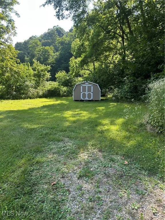 View of green lawn featuring a shed