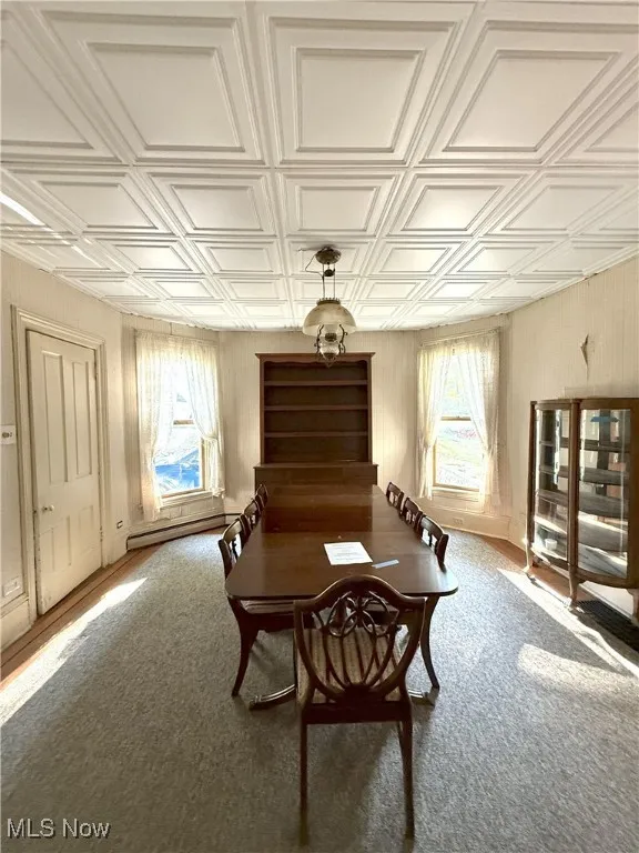 Formal Dining Room featuring an ornate tile ceiling, carpet rug over hardwood flooring, and a baseboard heating unit
