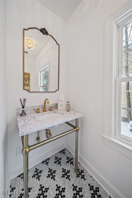 First floor half Bathroom featuring vanity and Carrara marbled flooring imported from Italy.