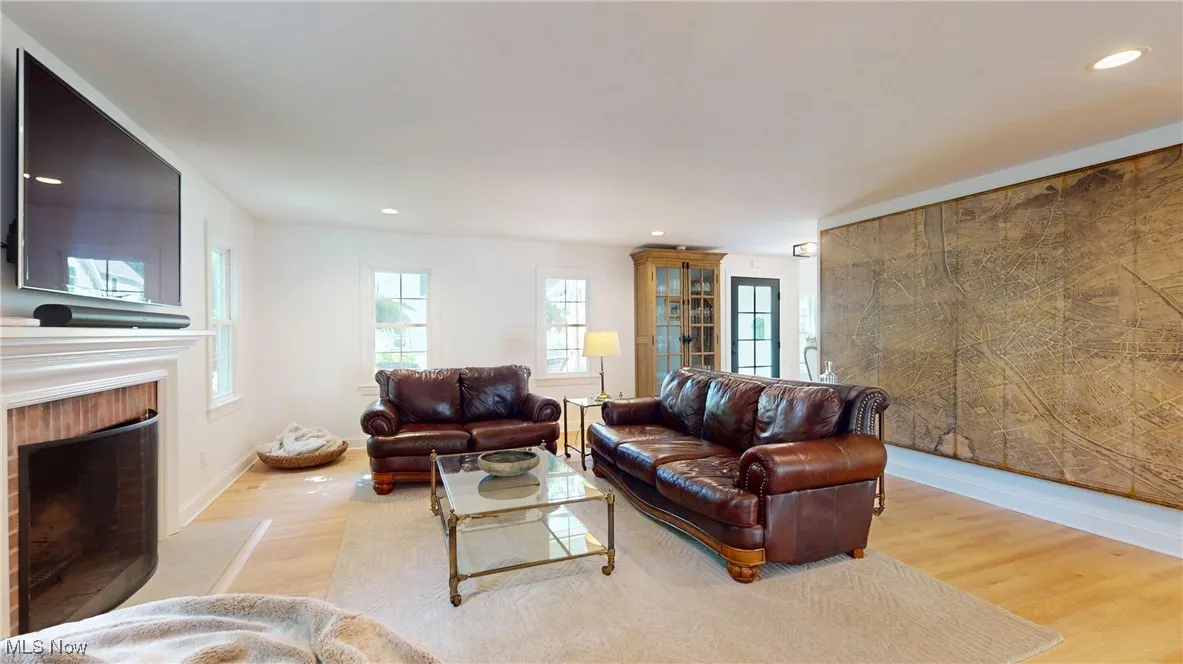 Living area lots of natural light, new wood wood floors, wood fireplace with beveled sandstone hearth