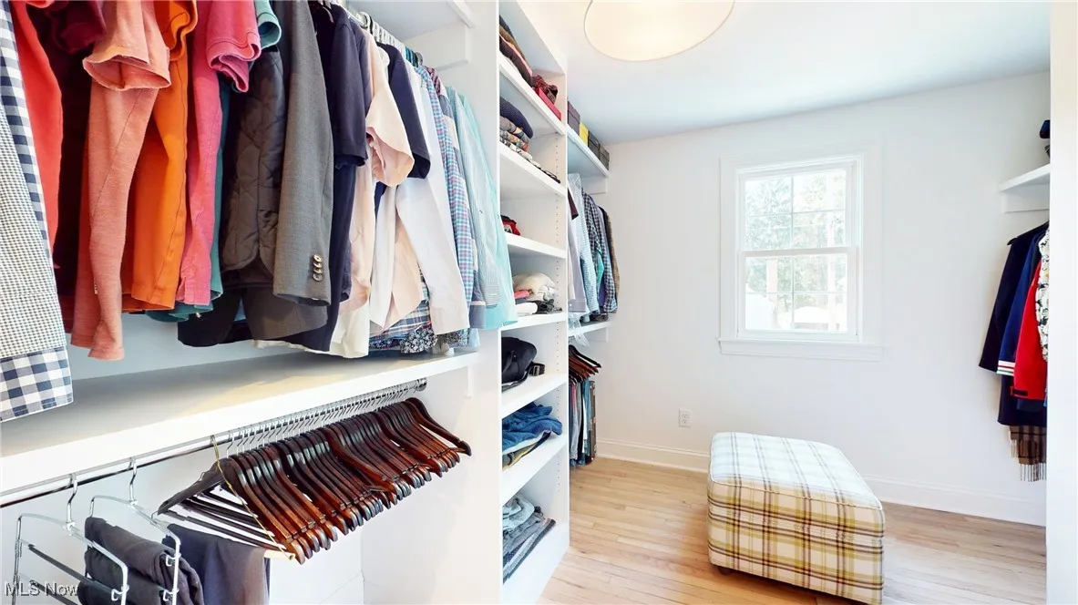 Primary Walk in closet with new wood finished wood floors