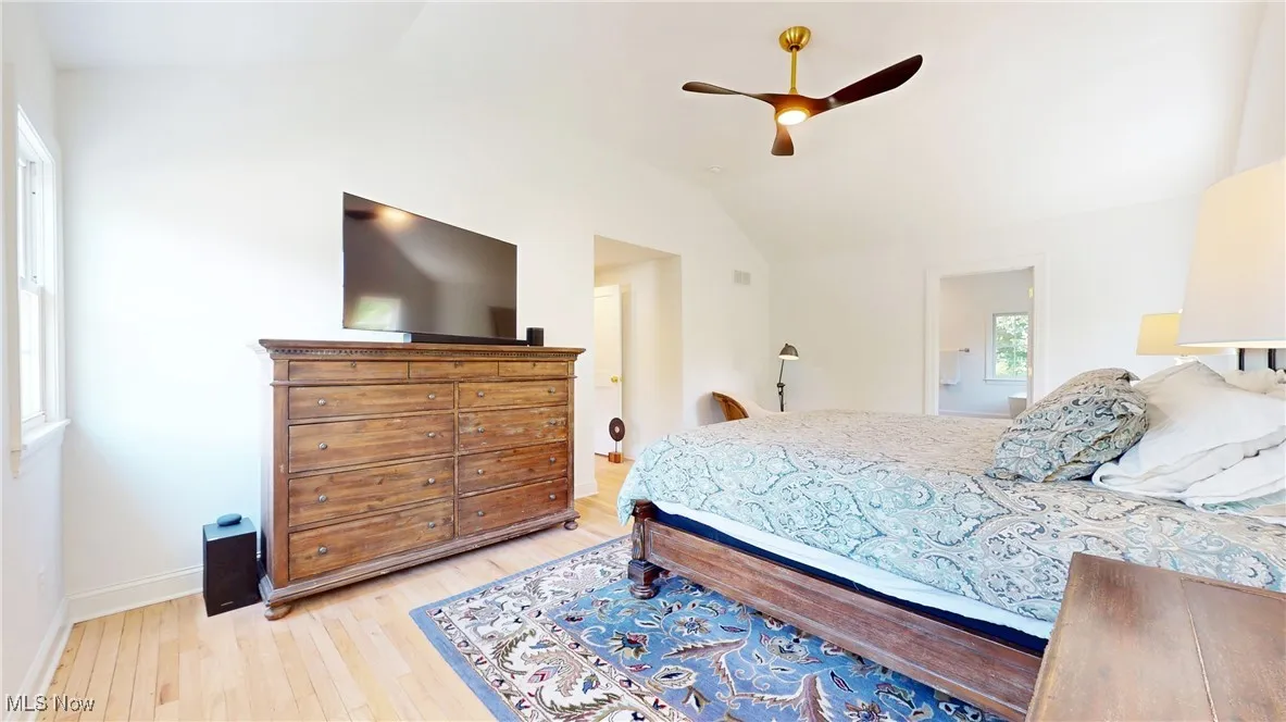 Primary bedroom with vaulted ceilings, ceiling fan, walk in closet and an ensuite bath