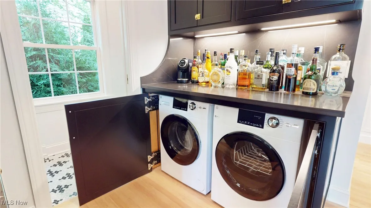 Hidden Laundry area with washing machine and clothes dryer, cabinet space, a dry bar
