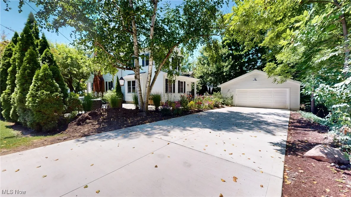 New contrete driveay leads to two car garage and bluestone terraces