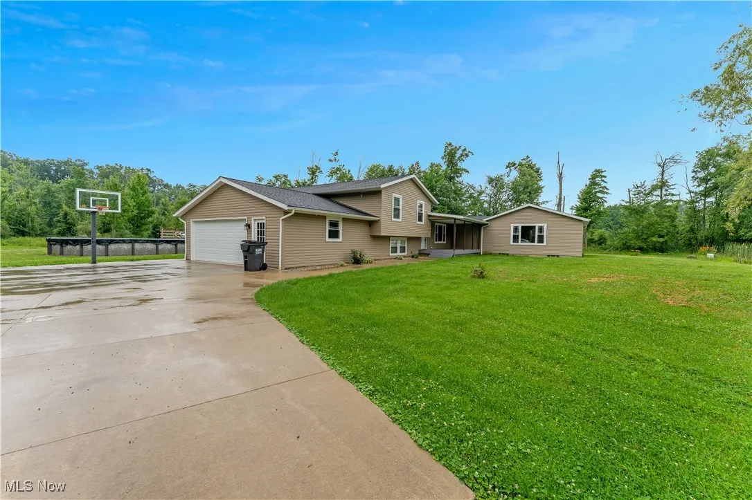 Split level home with driveway, a front lawn, and an attached garage