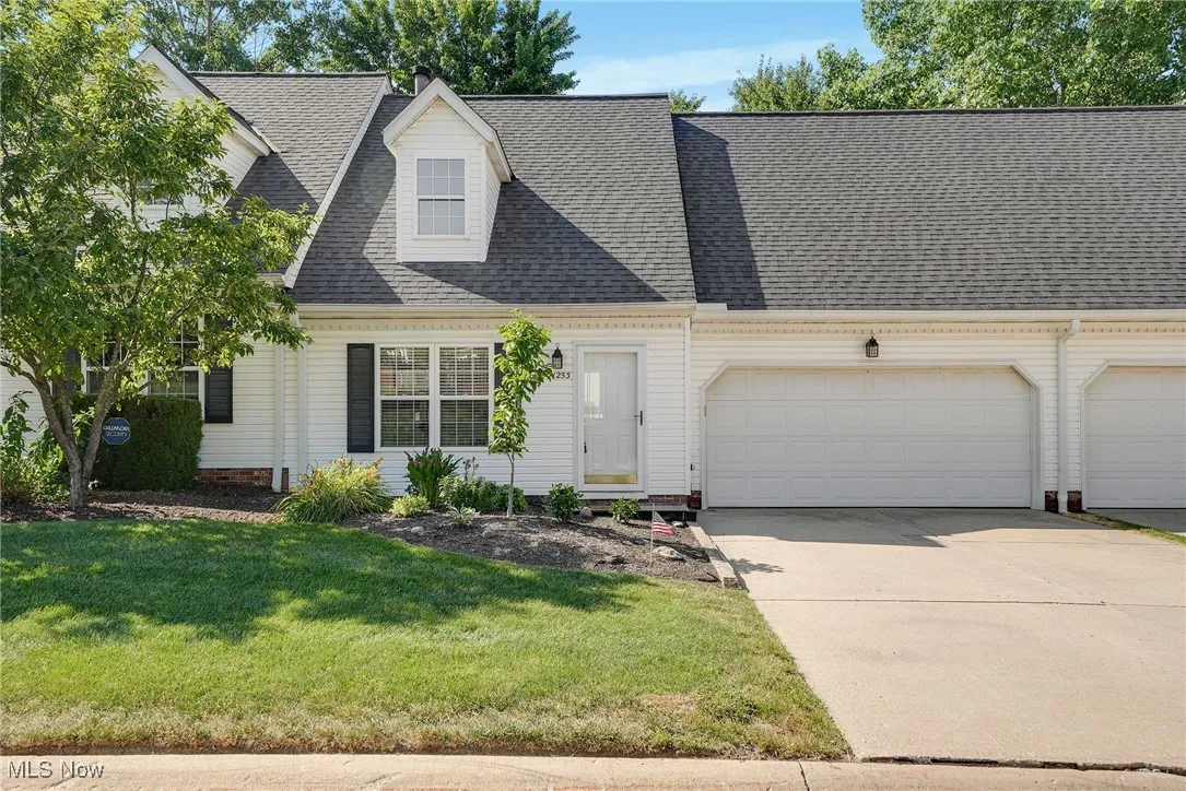 Cape cod home with a front yard, driveway, a garage, and roof with shingles