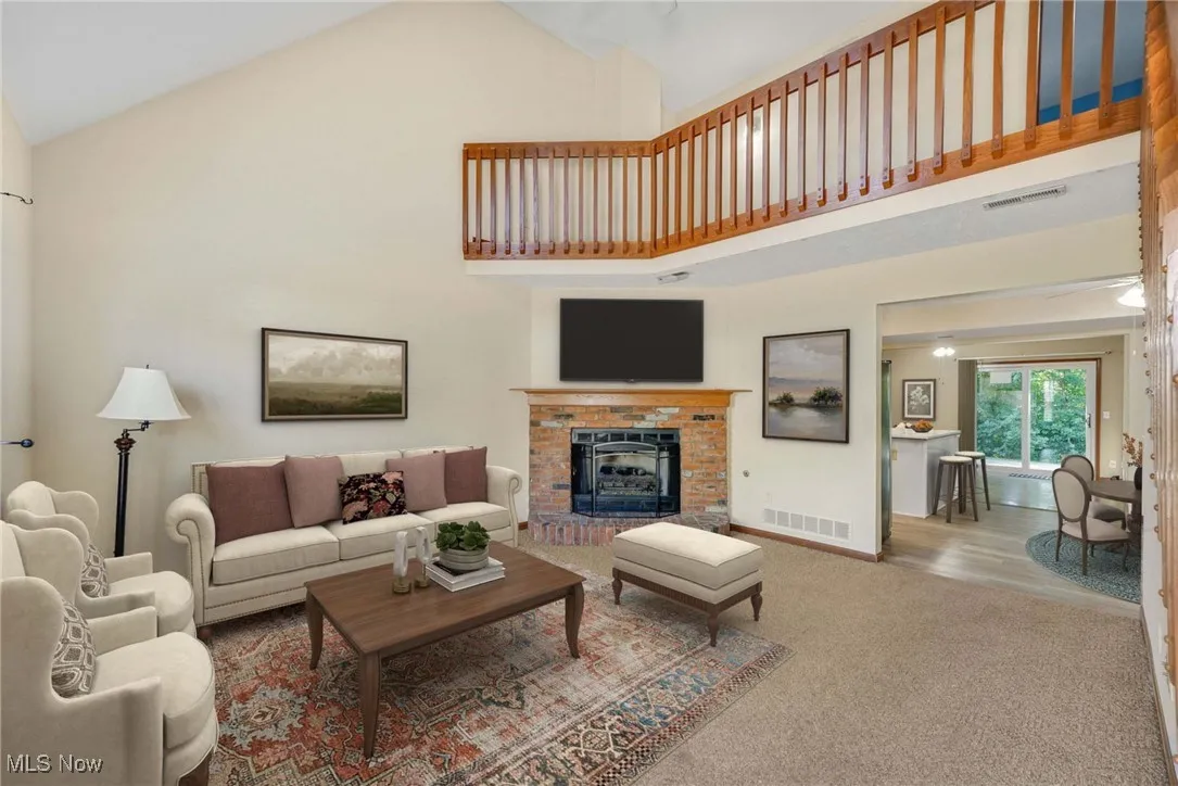 Virtually stage Living area with carpet flooring, high vaulted ceiling, and a fireplace