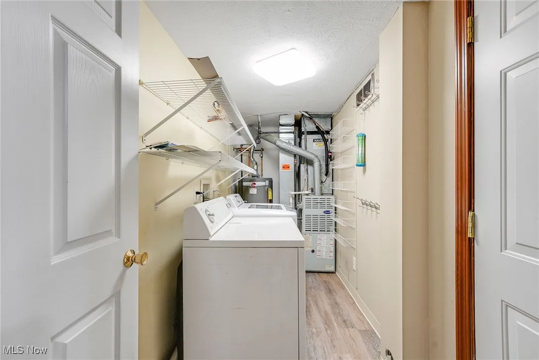 Laundry room featuring washing machine and clothes dryer and light wood-style floors