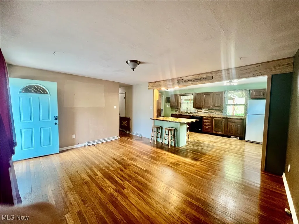 Unfurnished living room featuring light wood-type flooring and a sink