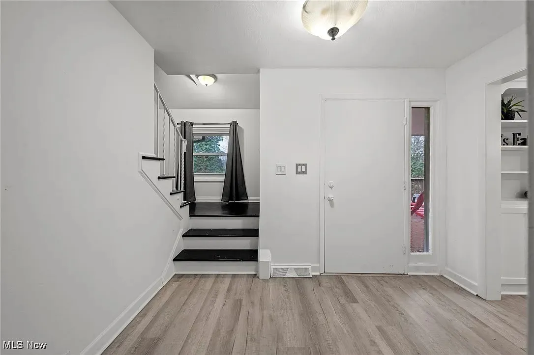 Entryway with wood finished floors and stairs