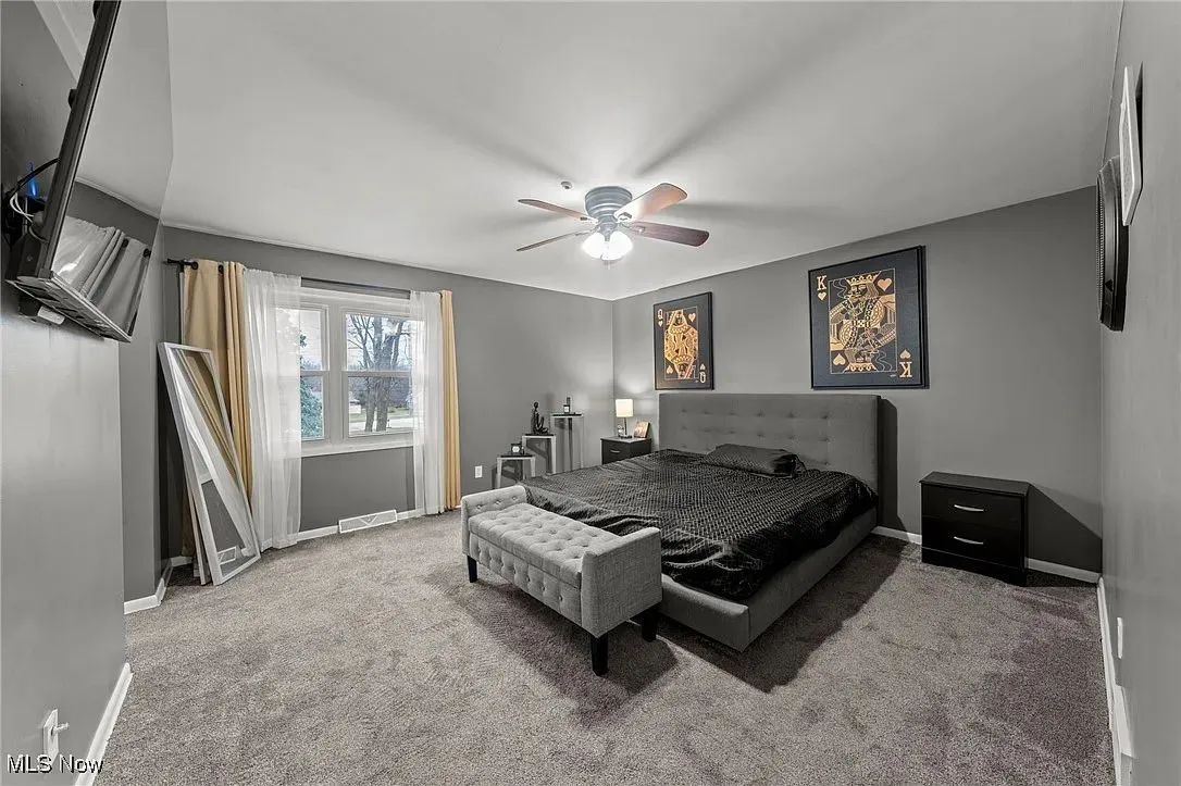 Carpeted bedroom with baseboards and a ceiling fan