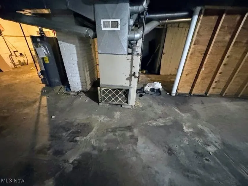 Unfinished basement with heating unit and water heater