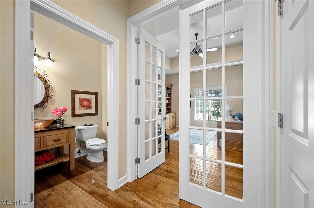 Bathroom with wood finished floors. French doors lead to the office