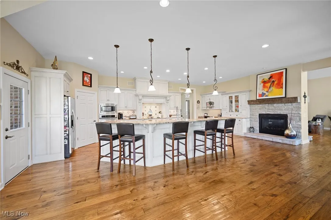 Kitchen with stainless steel appliances, light wood finished floors, recessed lighting, light countertops, and white cabinets