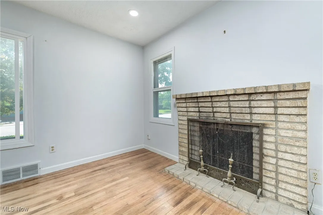 Unfurnished living room with a fireplace, wood finished floors, and recessed lighting