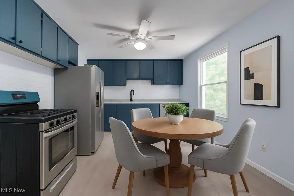 VIRTUALLY STAGED PHOTO! Kitchen featuring blue cabinetry, stainless steel appliances, tasteful backsplash, light countertops, and a ceiling fan
